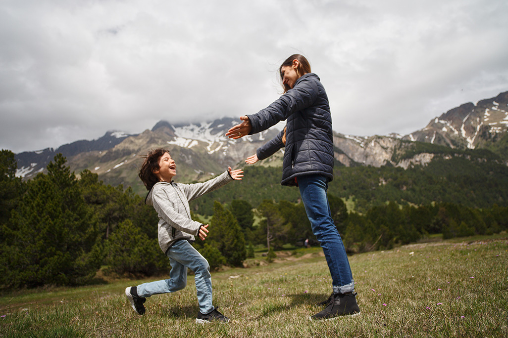 discussing sex, Tackling The Sex Conversation at Home with Your Son, image of son running to mom for a hug outside