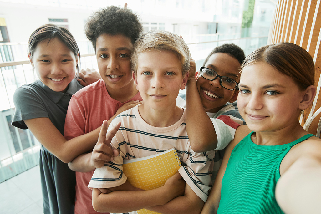 why is puberty starting earlier, image of young kids smiling at the camera